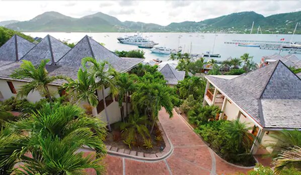 Ein Resort mit mehreren bungalowartigen Gebäuden, einem gepflasterten Weg und einer Marina mit Booten.