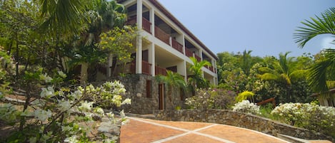 Un edificio de dos pisos con fachada de piedra y un balcón.