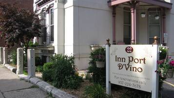 Experience the charm of Inn Port D'Vino, a classic inn with a welcoming entrance and cozy porch area.