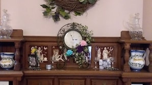 A fireplace mantel with a clock, decorative items, and a vase with a flower. - Inn Port Lodging (Dayton)
