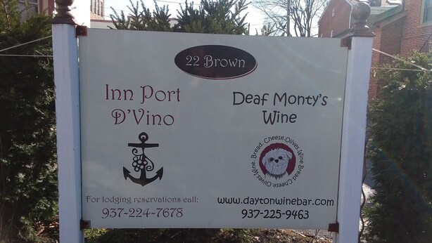A signboard for 'Inn Port D'Vino' and 'Deaf Monty's Wine' with contact numbers and a website URL. - Inn Port Lodging (Dayton)