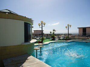 A rooftop pool with lounge chairs and potted plants, surrounded by buildings and a clear sky. - Hotel Windsor (Funchal)