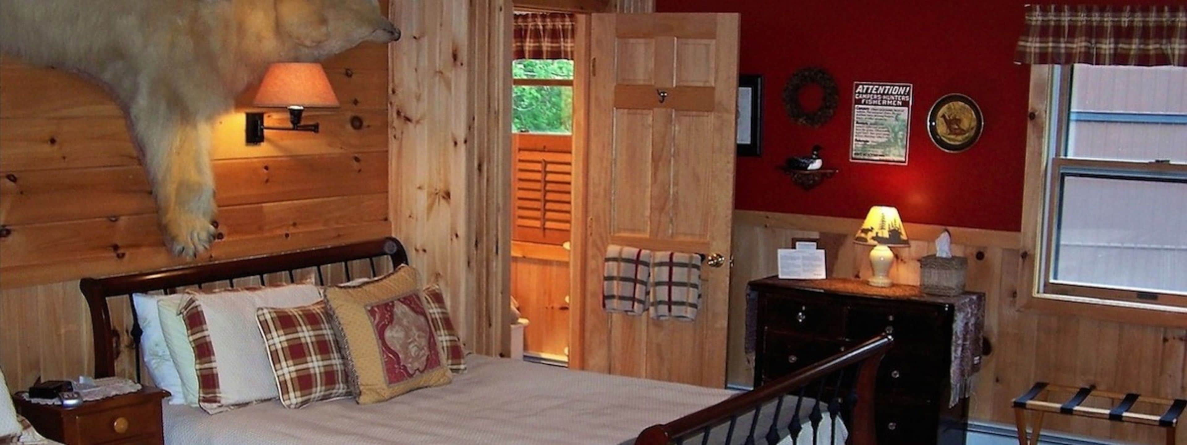 Ein Zimmer mit Holzboden, einem Bett, einem Nachttisch, einer Lampe und einer Wanduhr.