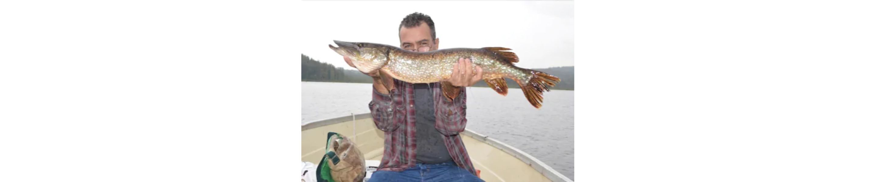 A person holding a large fish on a boat.
