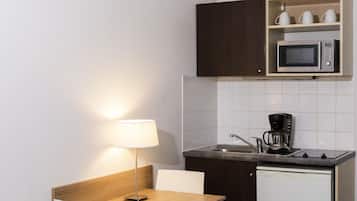 A compact kitchenette with a microwave, coffee maker, and a small sink.