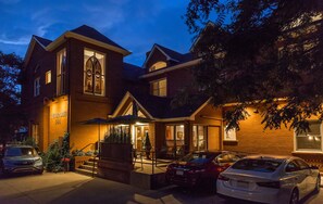 A two-story brick building with a prominent entrance, a covered porch, and a Christmas tree. - Bradley Boulder Inn (Boulder)