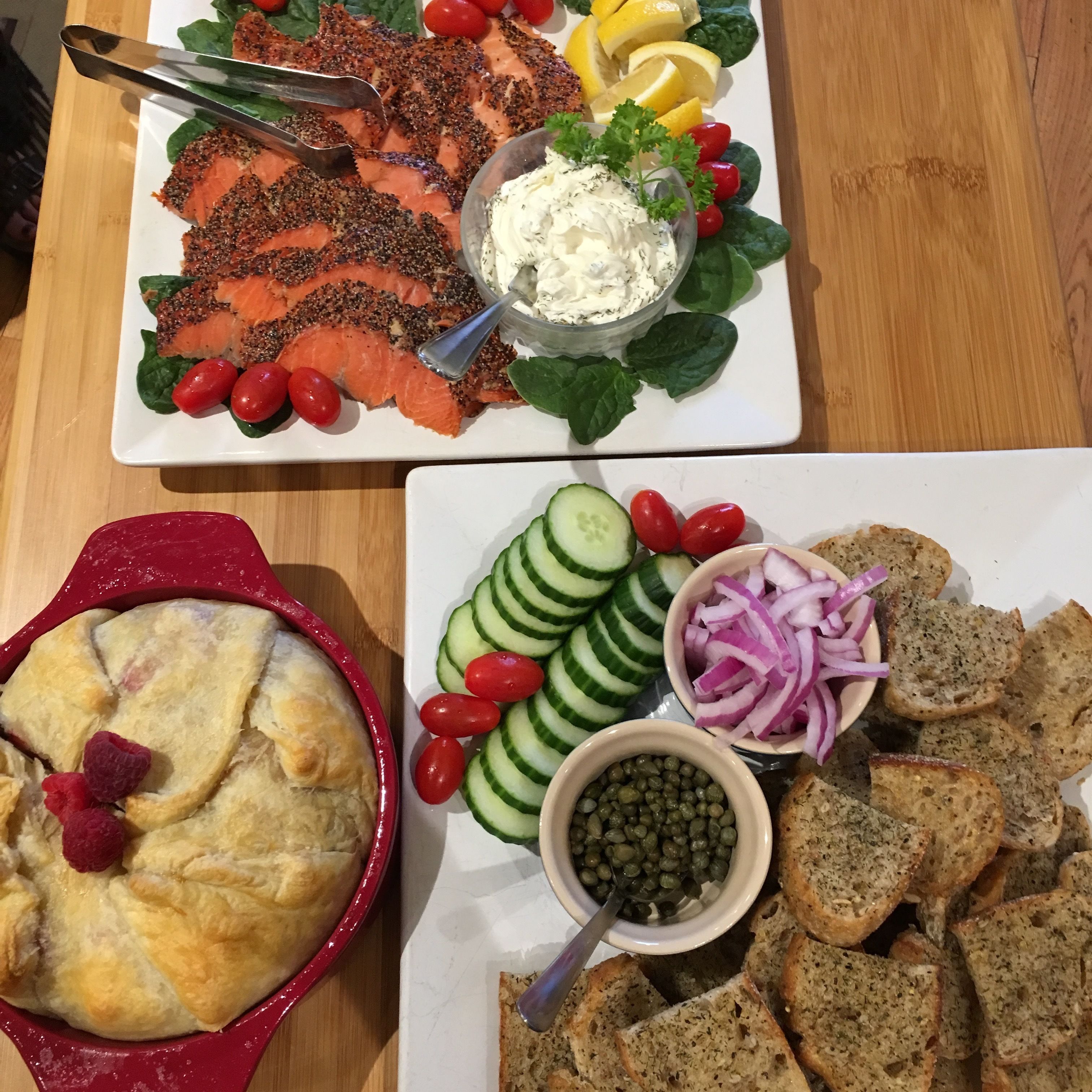 A table with a variety of food items including salmon, salad, and a baked dish.