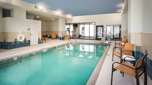 A swimming pool with lounge chairs and exercise equipment.