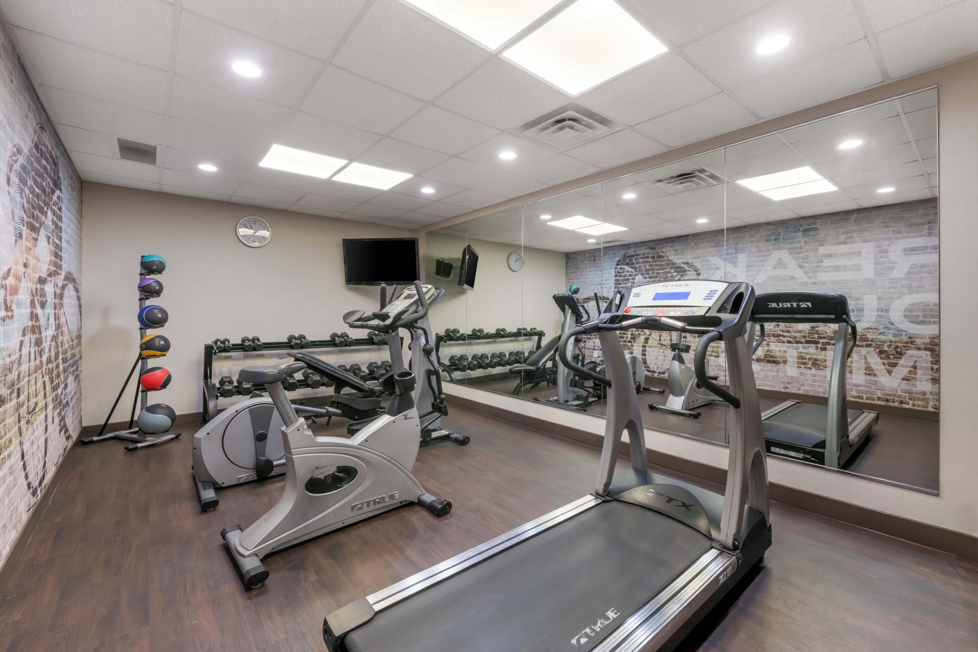 Un gimnasio con cintas de correr, elípticas y pesas.