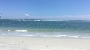A beach with a fishing rod on the sand and the ocean in the background. - Surf and Sand, BW Signature Collection (Fernandina Beach)