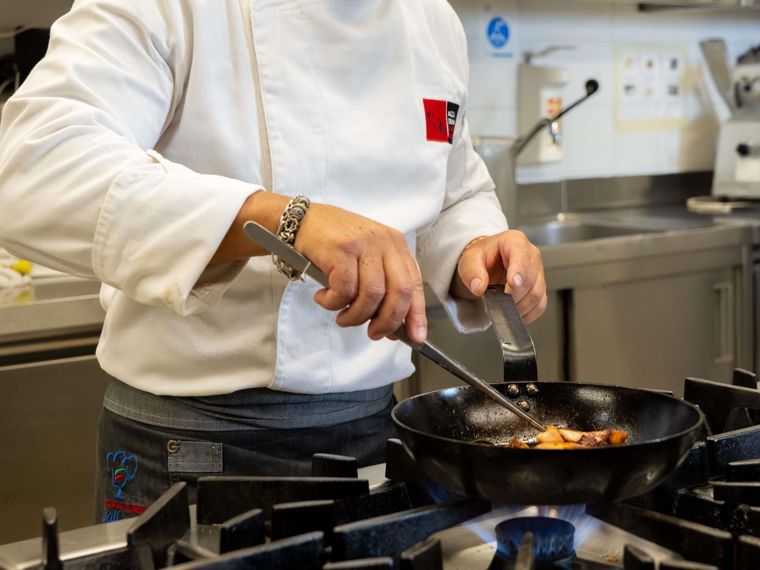 Une personne qui cuisine dans une cuisine équipée d’une cuisinière et d’une poêle.