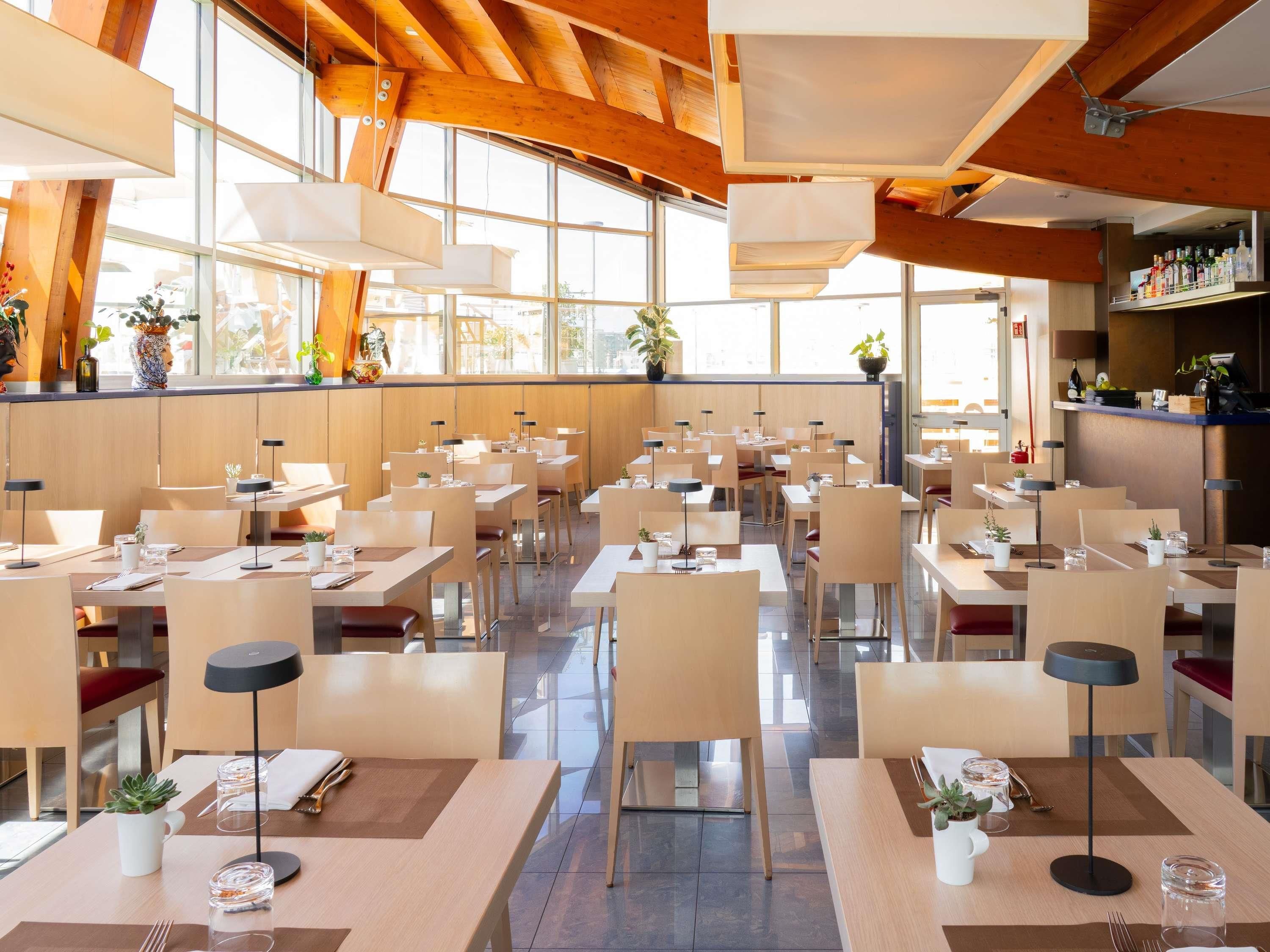 A spacious restaurant with high ceilings, large windows, and a modern interior design.