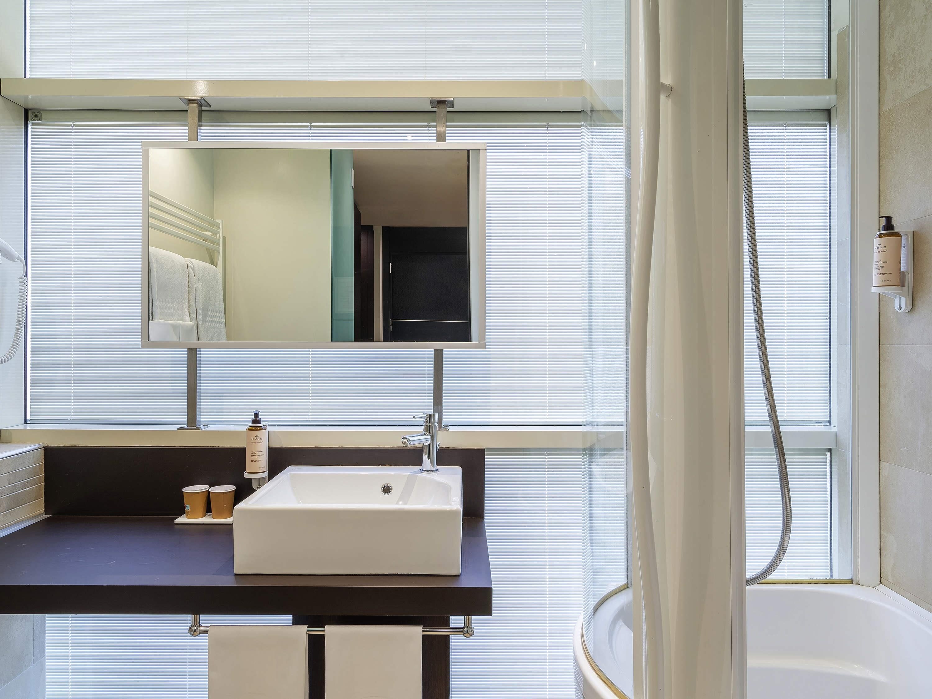 Ein Badezimmer mit Waschbecken, Spiegel und Dusche.