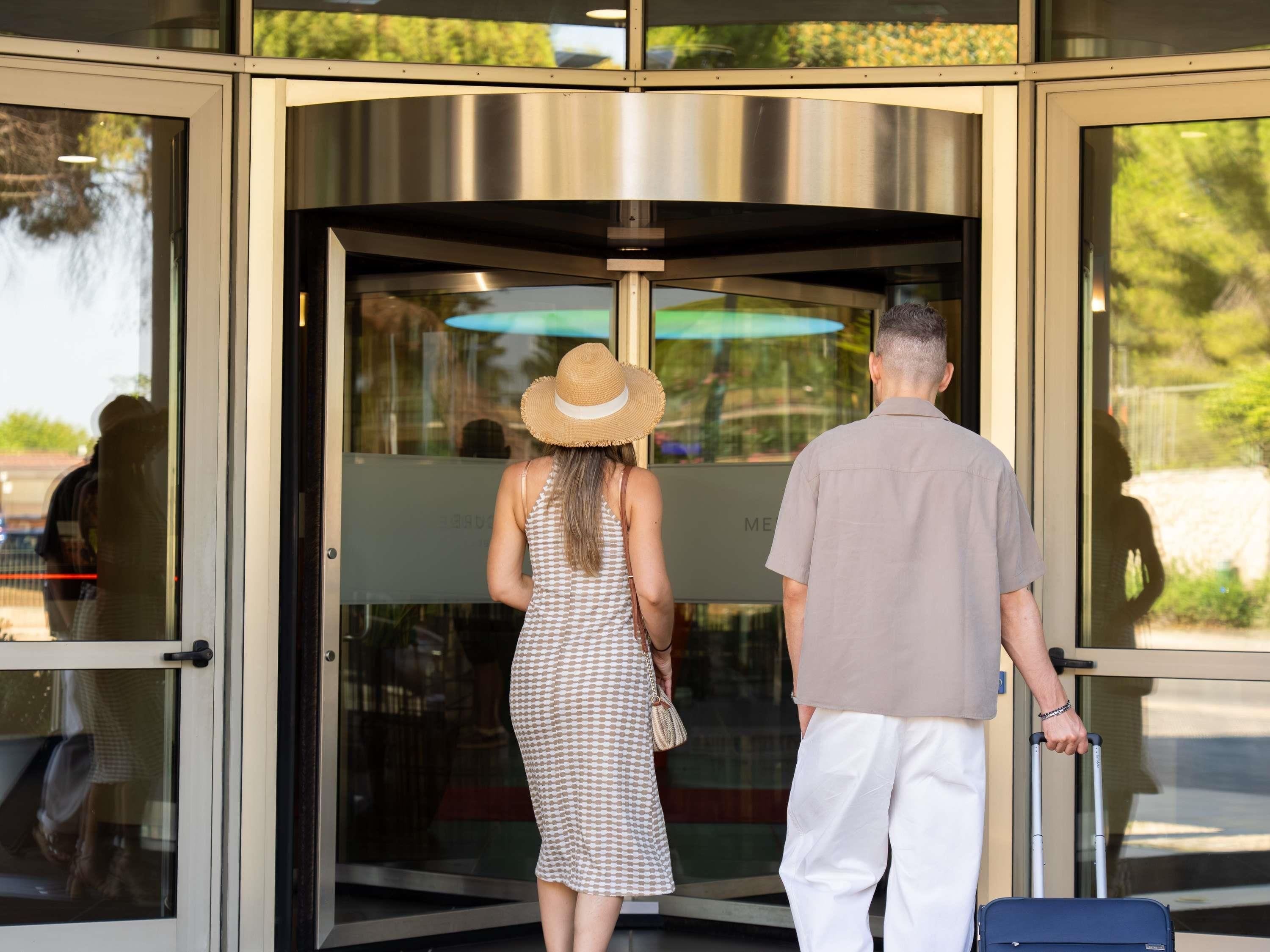 A revolving door with glass panels and a metal frame.