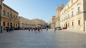 A spacious public square with historic buildings, a clock tower, and a clear sky. - Mercure Siracusa Prometeo (Syracuse)