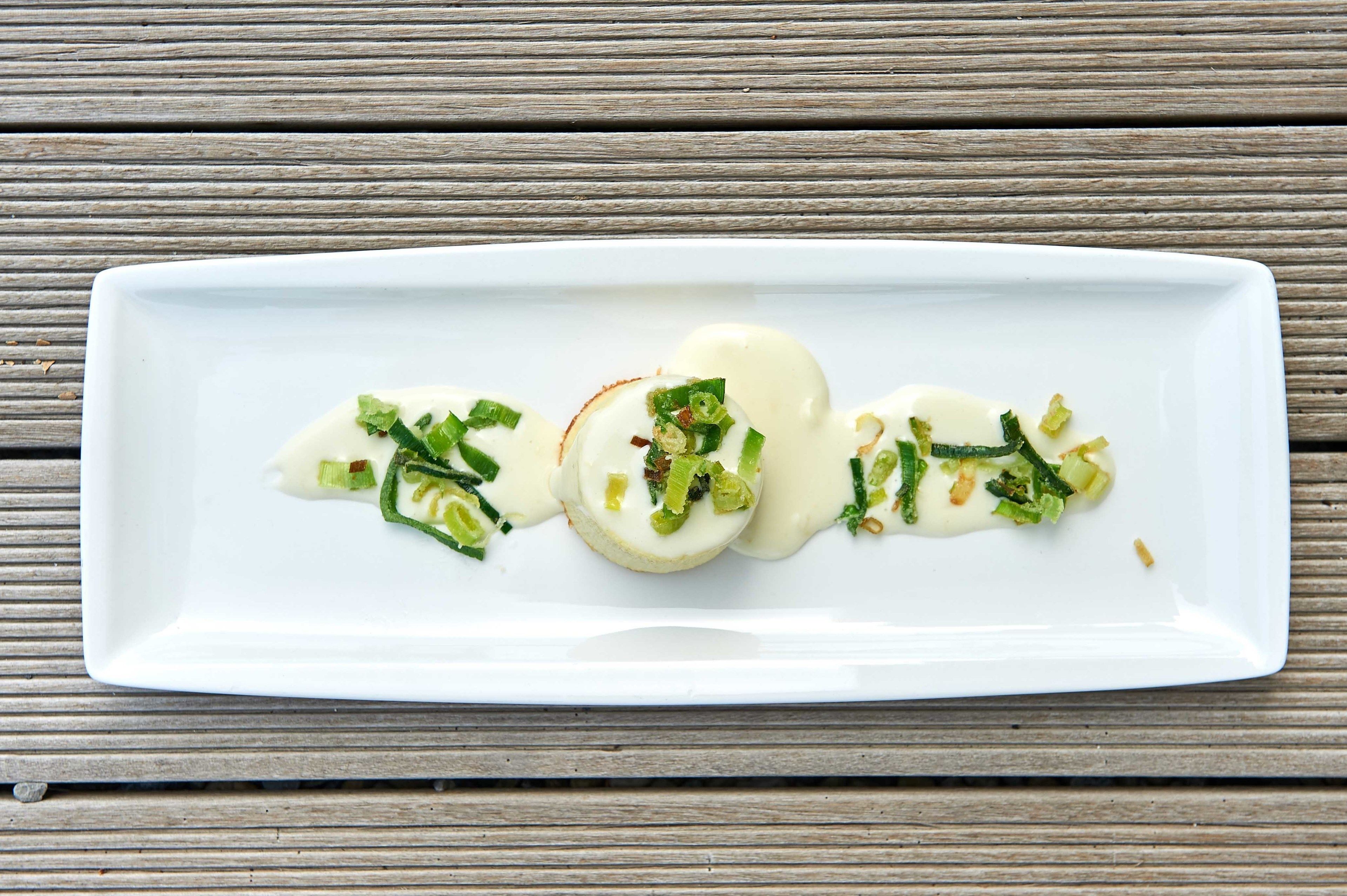 A white rectangular plate with a food arrangement on a wooden surface.