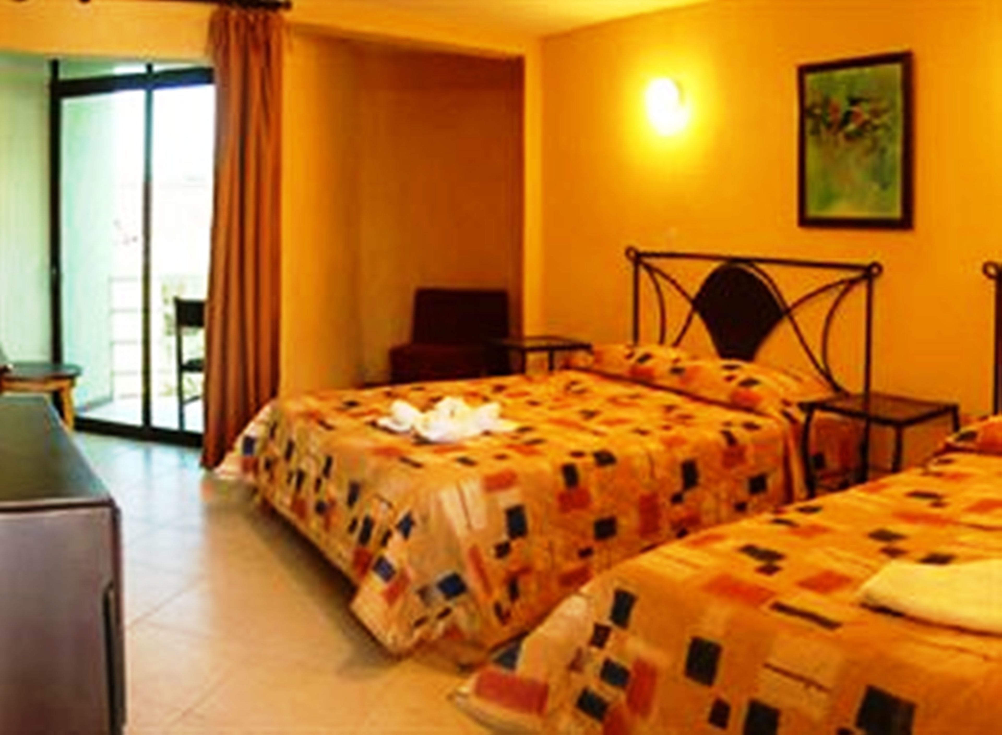 A hotel room with two beds, a desk, and a chair.