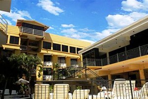 A multi-story building with balconies, a staircase, and outdoor seating areas.