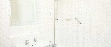 A bathroom with a sink, mirror, shower, and toilet.