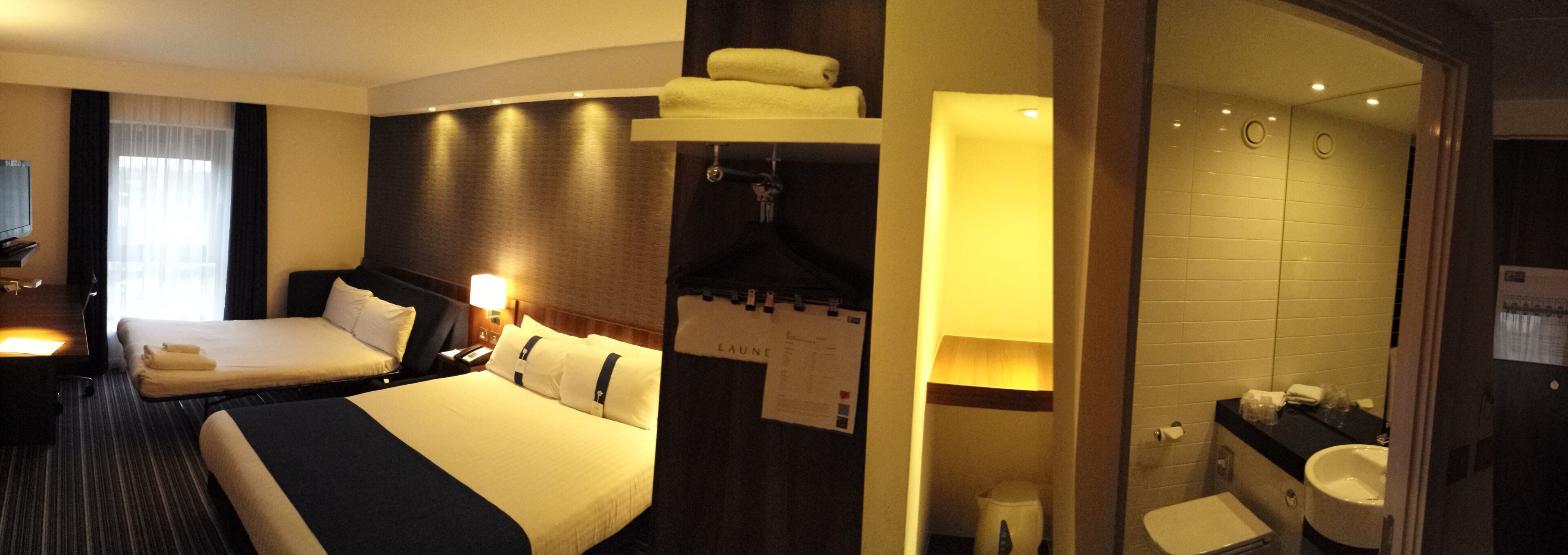 Une chambre d’hôtel avec deux lits, une salle de bain et un espace douche.