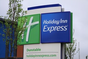 A Holiday Inn Express sign with a green and blue logo, and the name 'Dunstable' below it. - Holiday Inn Express Dunstable by IHG (Dunstable)