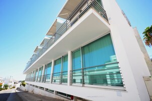 Un bâtiment moderne doté de grandes fenêtres et d’un balcon.