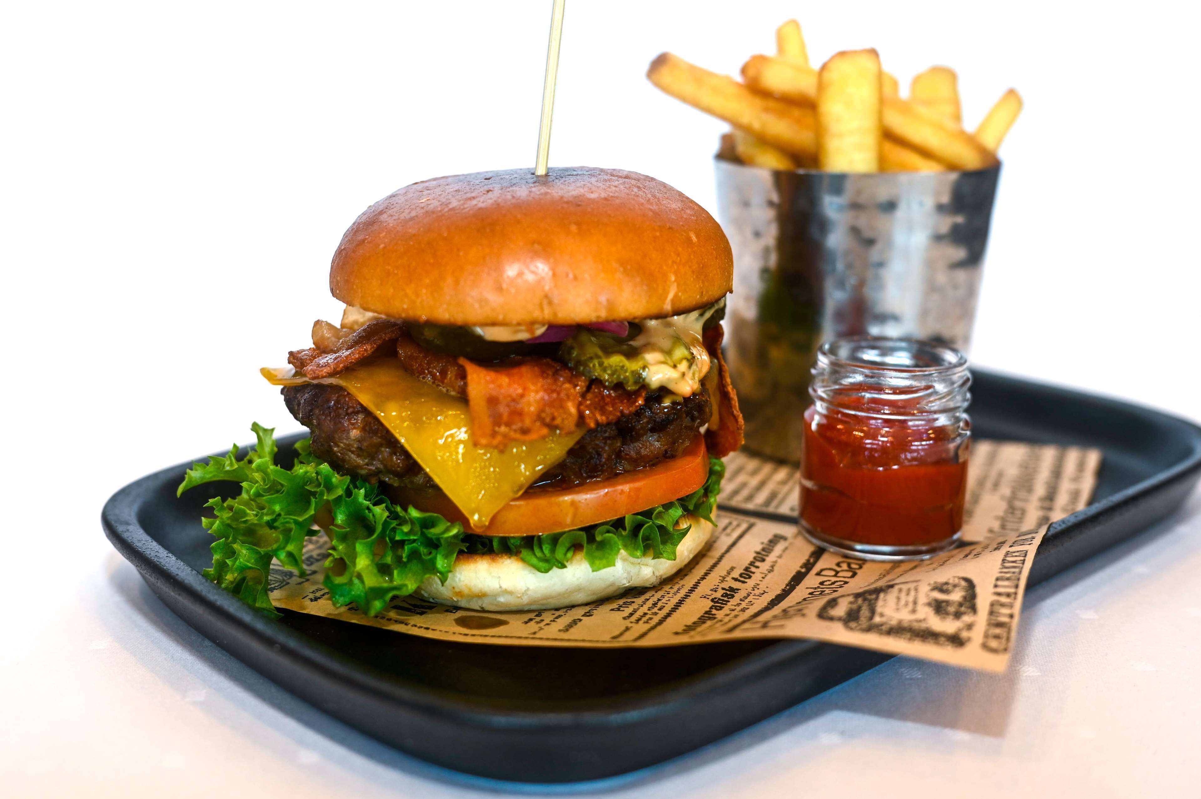 Ein Burger mit Pommes und Ketchup auf einem Tablett.
