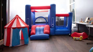 Kids can play in the room's play area with a bouncy castle and a tent.