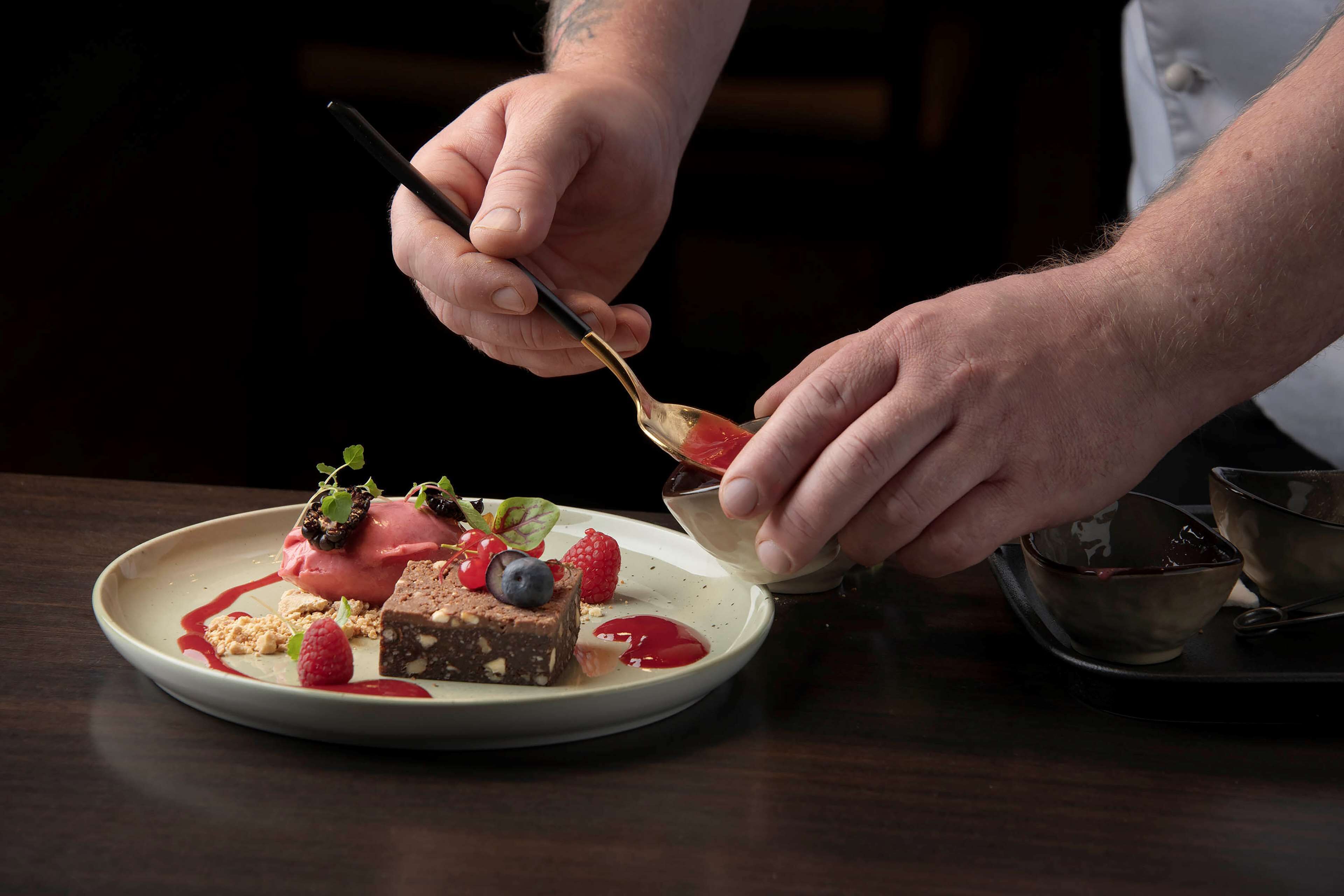 Iemand serveert dessert op een bord met een lepel.