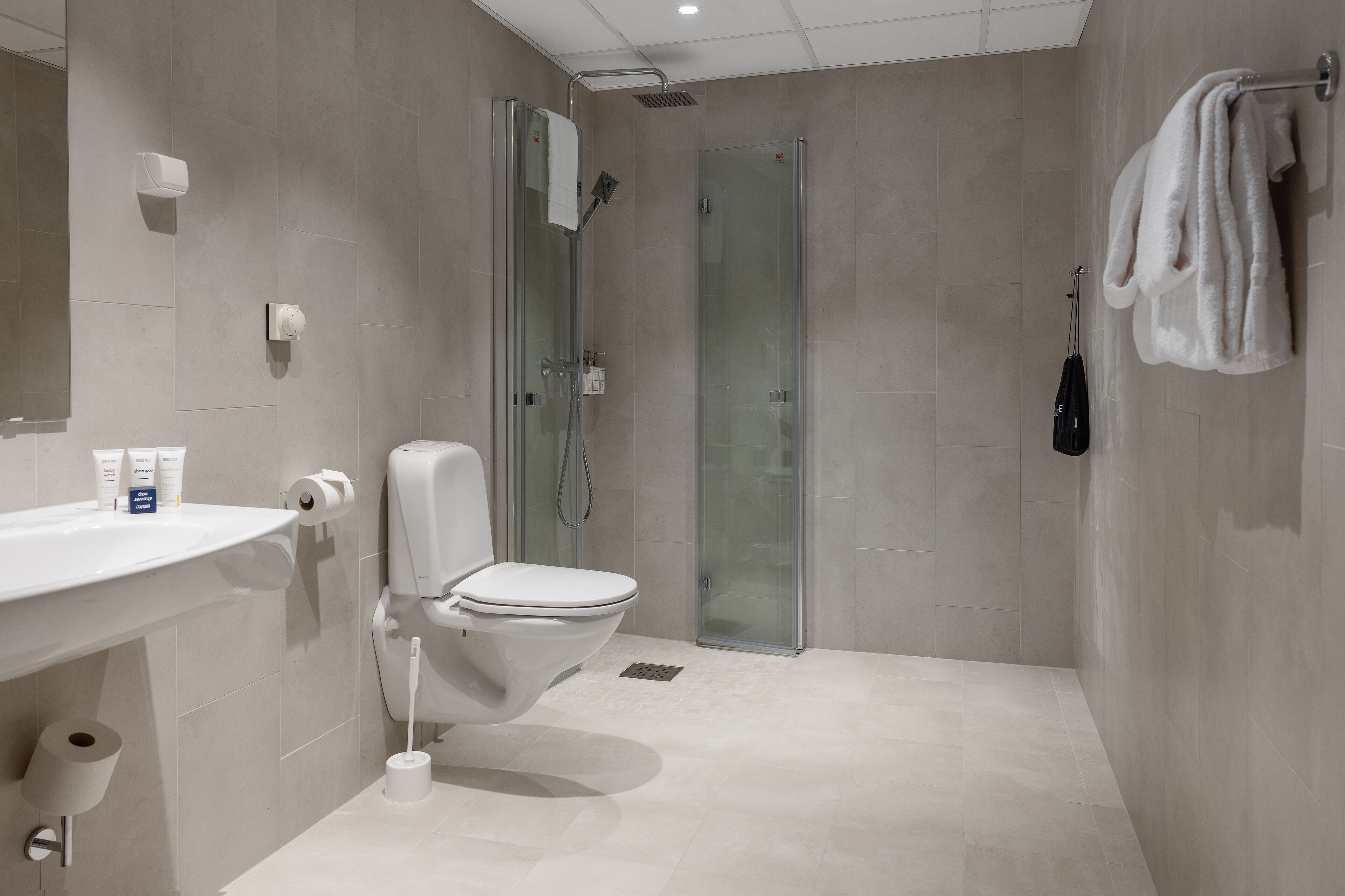 A modern bathroom with a toilet, sink, and shower.