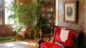 A room with a red sofa, a wooden cabinet, and a large potted plant.