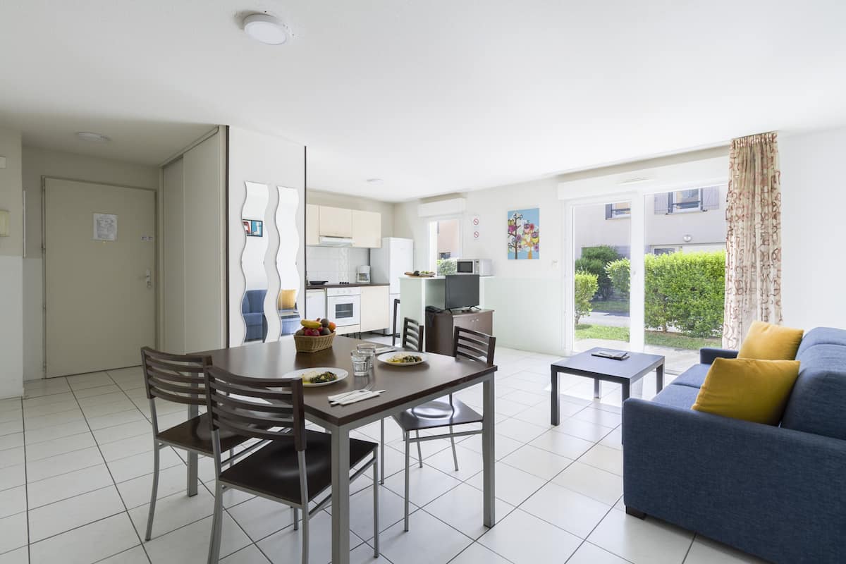 Un appartement moderne comprenant un coin repas, une cuisine et un salon.