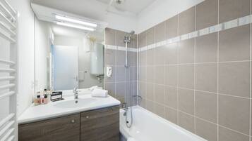 A modern bathroom with a double sink vanity, a bathtub, and a shower.