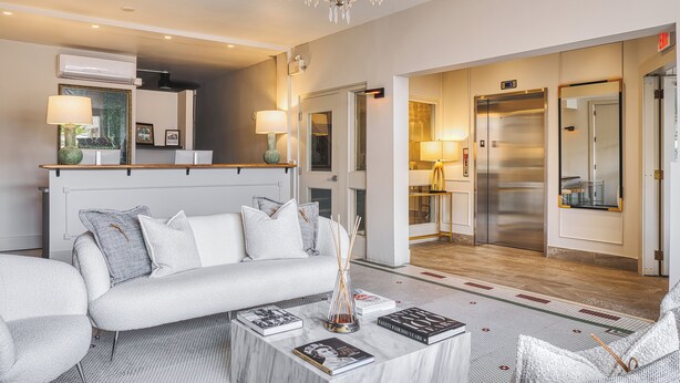 Un moderno vestíbulo de hotel con sofá, mesa de centro y candelabro.