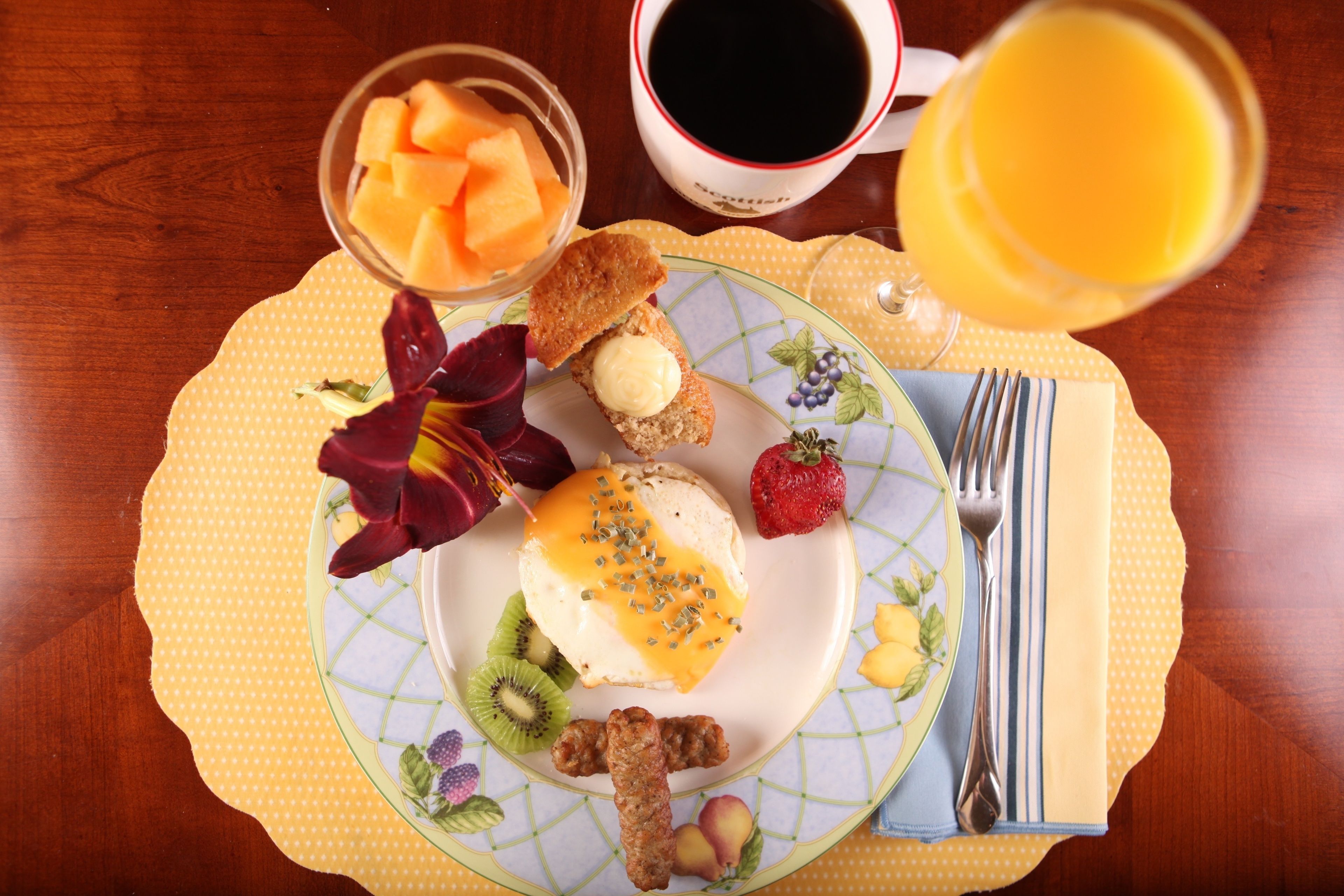 A breakfast plate with toast, butter, fruit, and a drink.