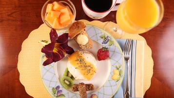 A breakfast plate with toast, butter, fruit, and a drink.