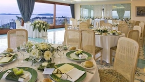 A dining area with round tables set for a meal, featuring green plates and white tablecloths. - Le Querce Resort Sea Thermae & SPA (Ischia)