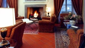 Una sala de estar acogedora con chimenea, asientos cómodos y vistas al exterior.