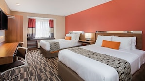 A hotel room with two beds, a desk, and a TV. - Microtel Inn & Suites by Wyndham Walterboro (Walterboro)