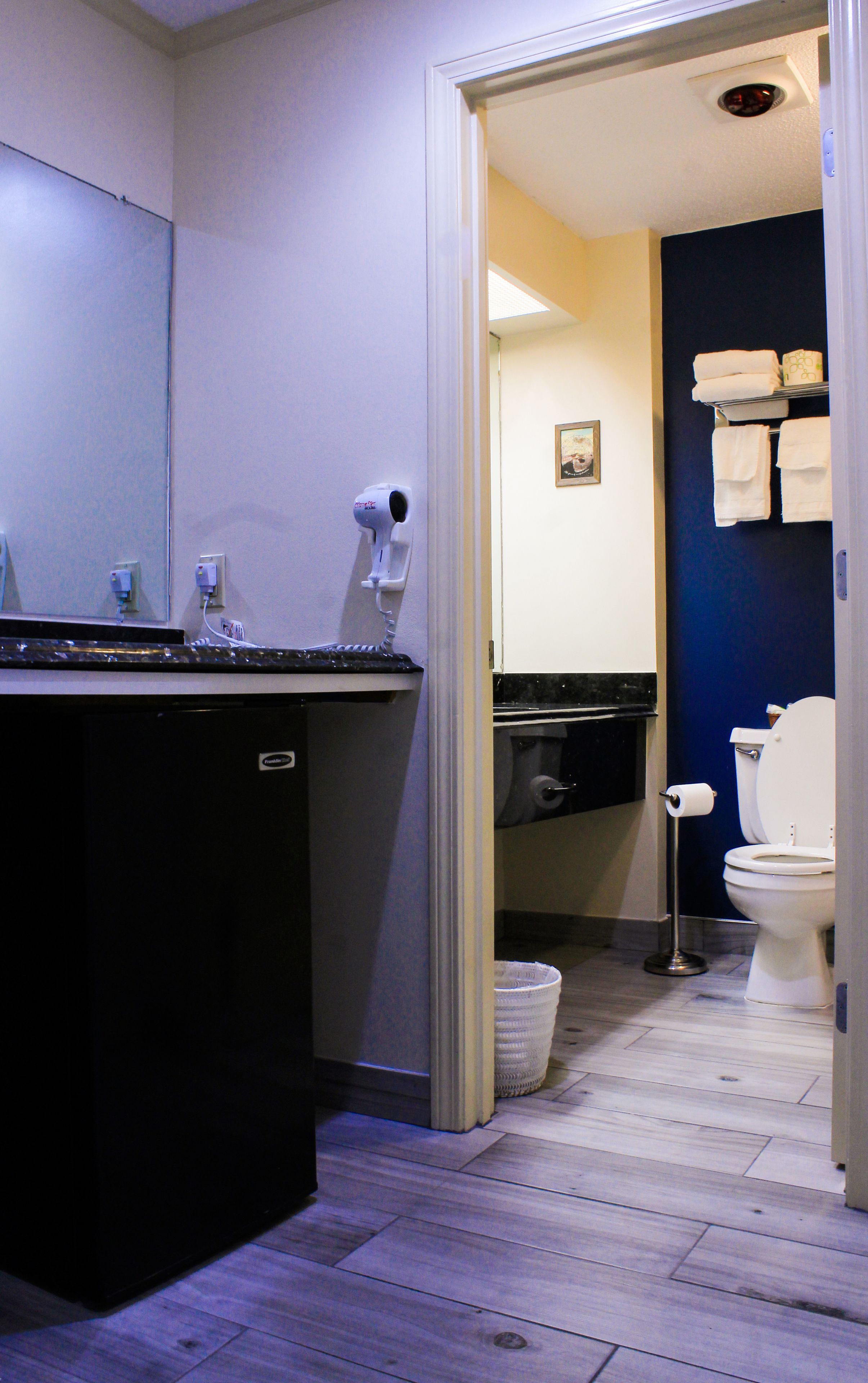 Ein Badezimmer mit einem schwarzen Waschbecken, einer Toilette und einer Duschkabine.