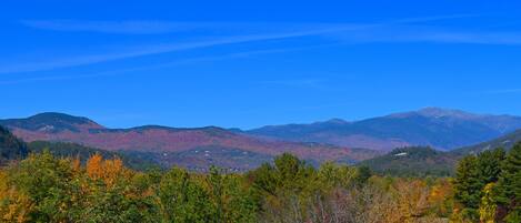A mountainous landscape with autumn foliage and clear blue skies.