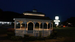 A gazebo with a white picket fence and a sign indicating a motel in the background.