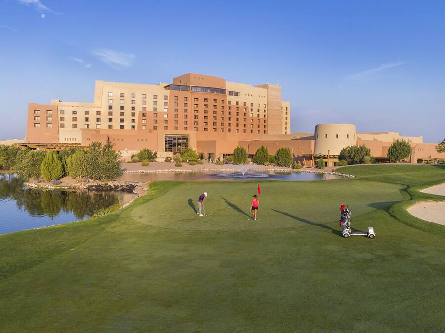 A golf course with a large building in the background.