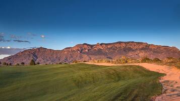 Un campo de golf con montañas al fondo.