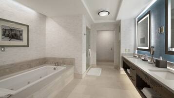 A modern bathroom with a large bathtub, a walk-in shower, and a vanity with a mirror.