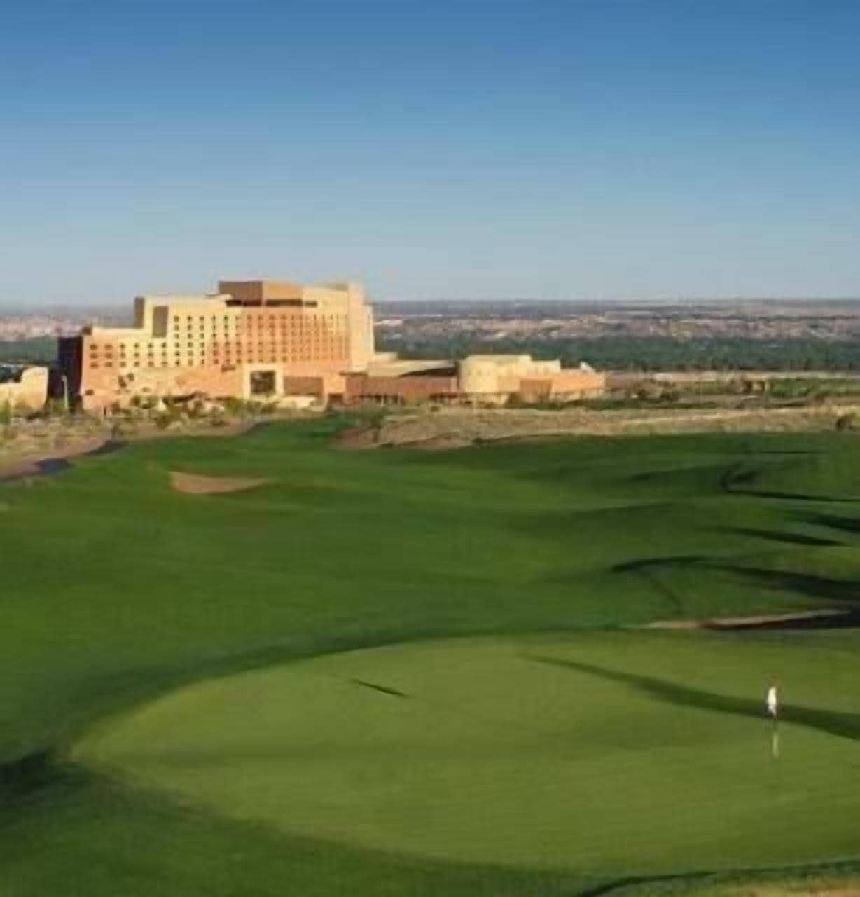 Un campo de golf con un edificio al fondo.