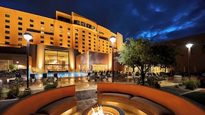 Un hotel con piscina, mobiliario exterior y una fogata.