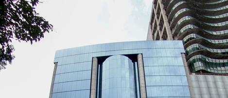 Un bâtiment moderne doté d’une façade en verre réfléchissant et d’une entrée imposante.