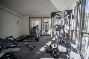 A gym with exercise equipment, a treadmill, and a weight rack. - El Diplomatico Hotel (Mexico City)