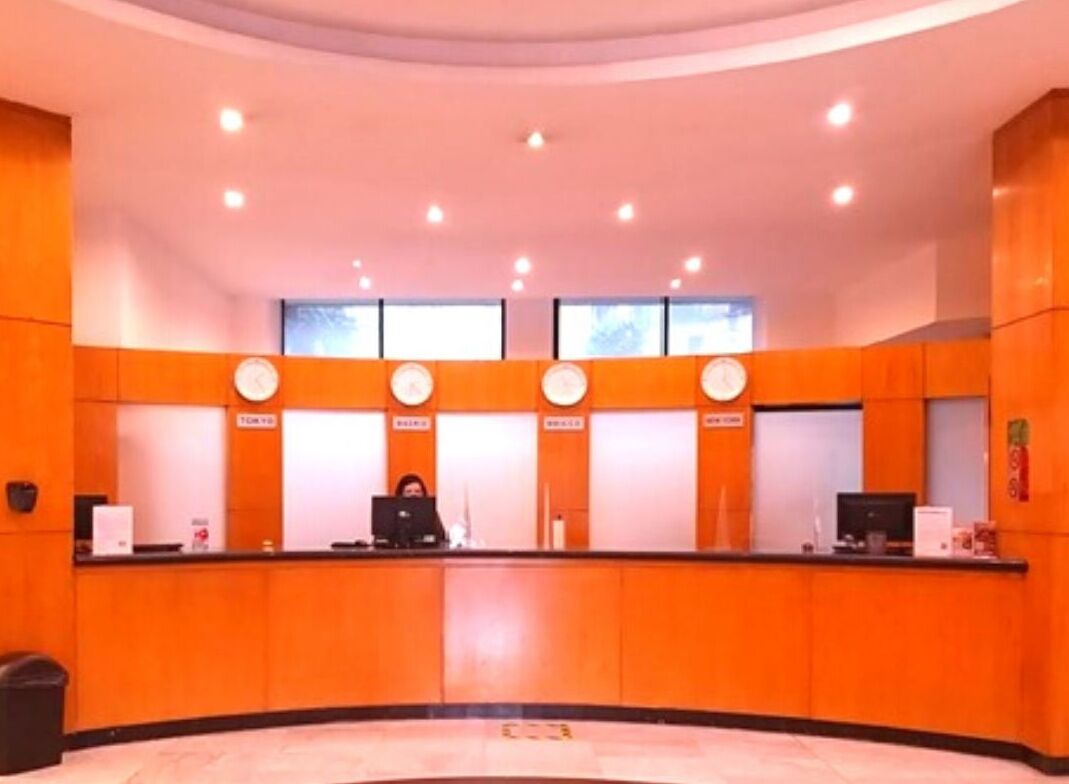 A reception area with a curved counter, multiple service windows, and a tiled floor.